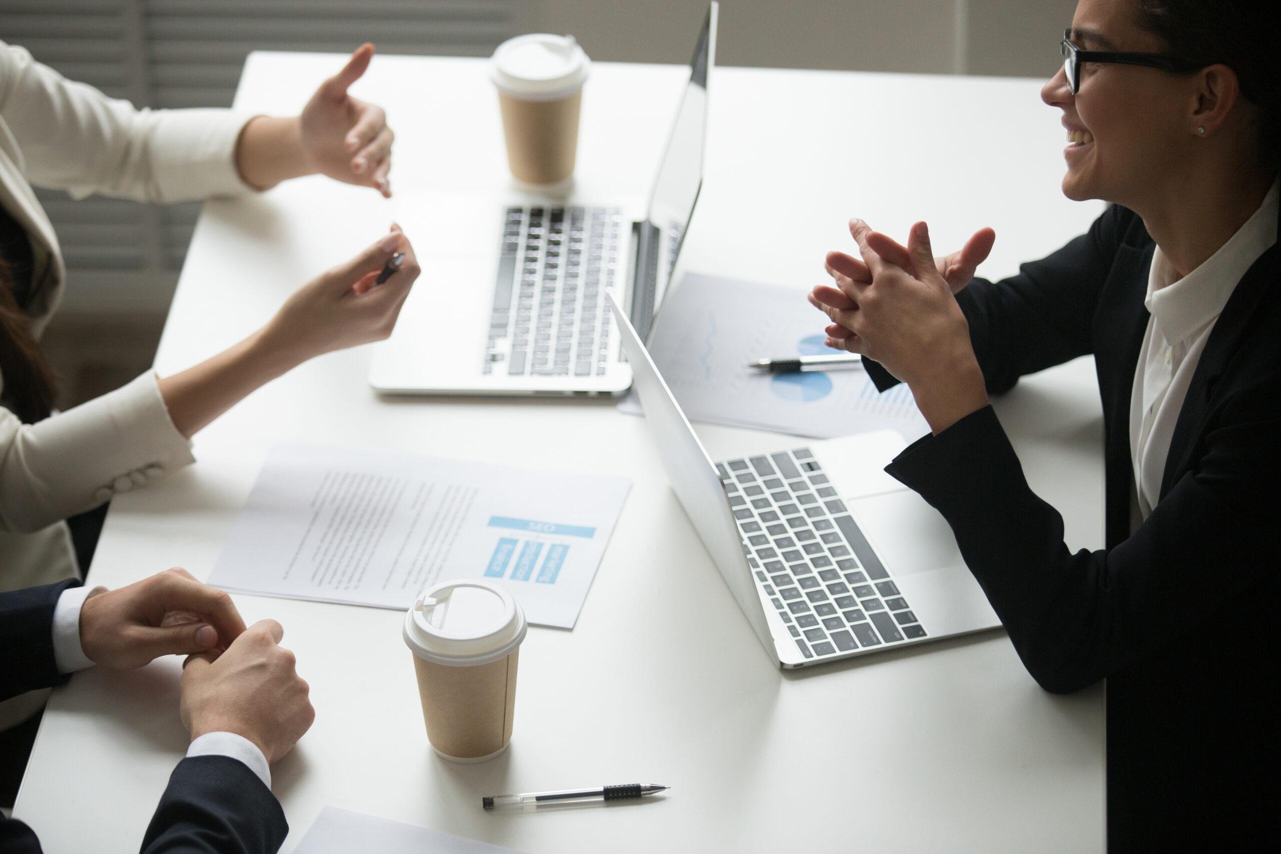 smiling-businesswoman-enjoying-talk-with-colleagues-teamwork-with-laptops-1-scaled.jpg